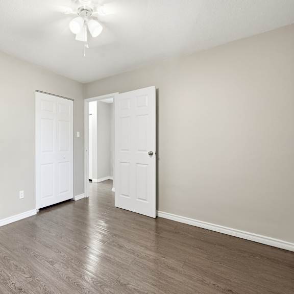 a room with a ceiling fan and two doors.
