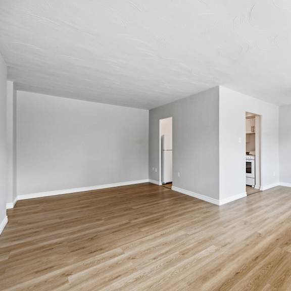 a room with wooden flooring and white walls.