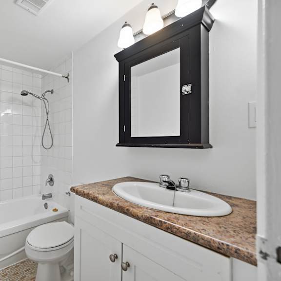 a white bathroom with a sink, toilet and bathtub.