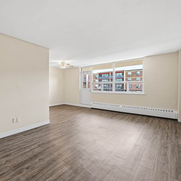 a room with wooden flooring and a window with a view of a building.