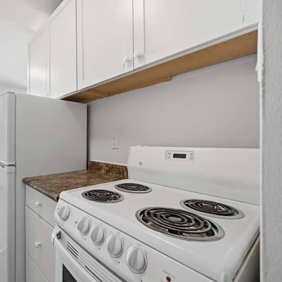 a white stove with a window above it in a kitchen.