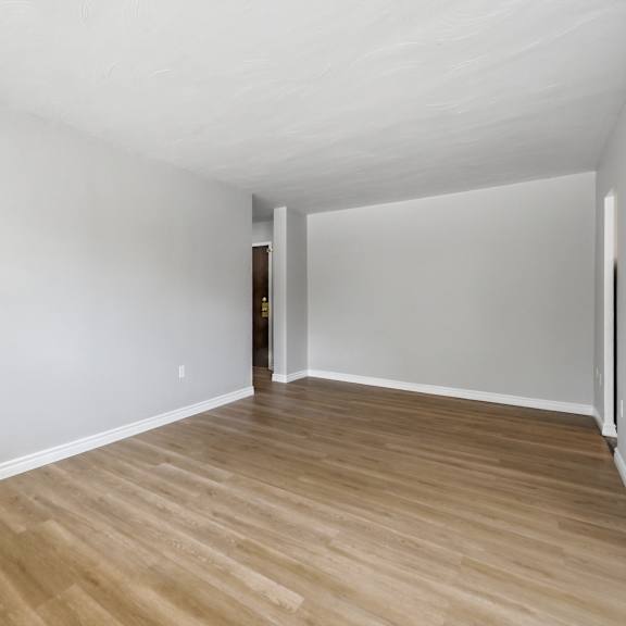 a room with wooden flooring and white walls.