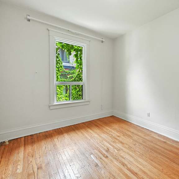 a room with a window and wooden flooring.