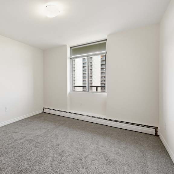 a room with a window and carpeted floor.