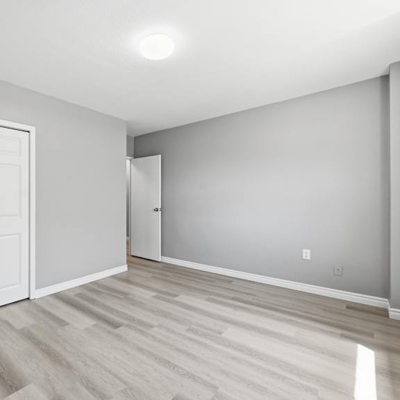 a room with a white door and a wooden floor.