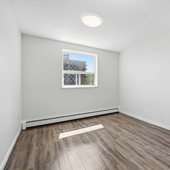a room with a window and wooden flooring.