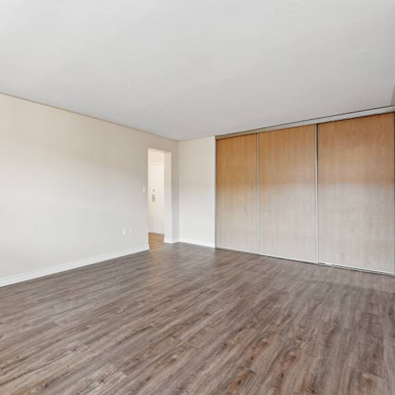 a room with wooden flooring and a wall with a door.