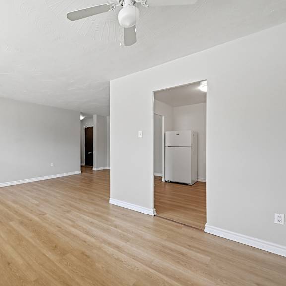 a room with a ceiling fan and a doorway leading to another room.