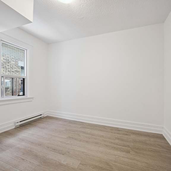 a room with a window and a wooden floor.