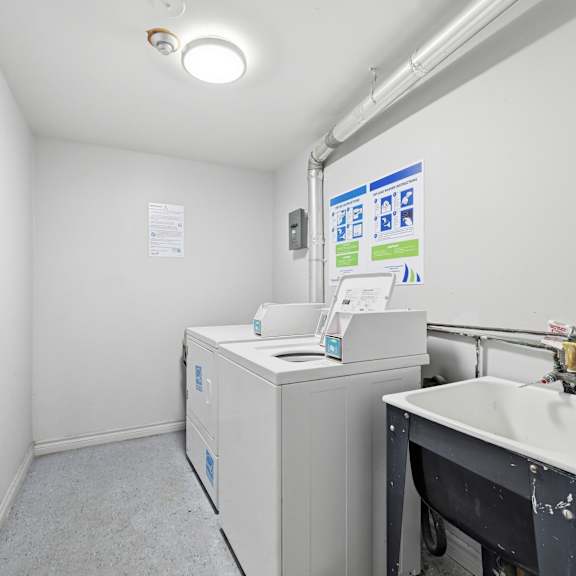 a bathroom with a sink, toilet, and a poster on the wall.