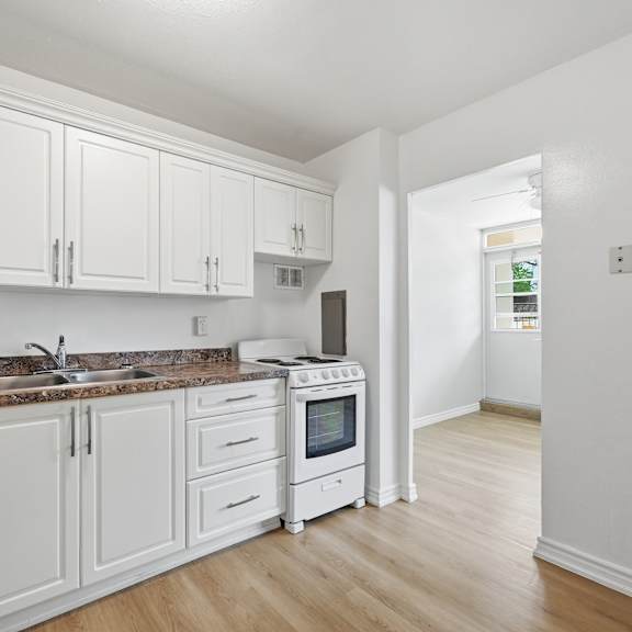 a kitchen with white cabinets and a brown countertop.