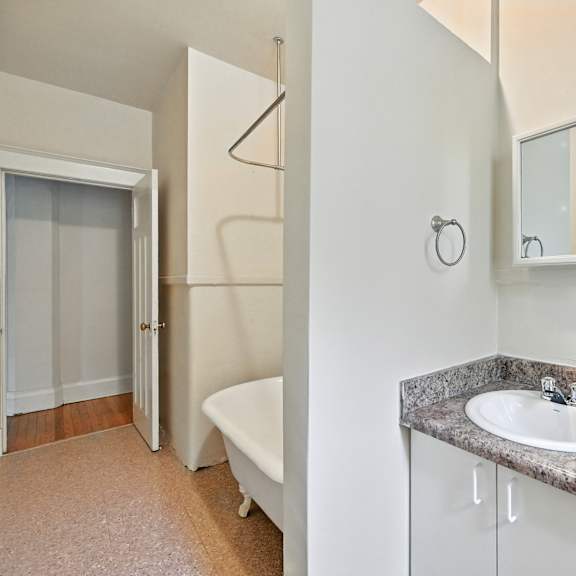 a bathroom with a sink, mirror, and bathtub.