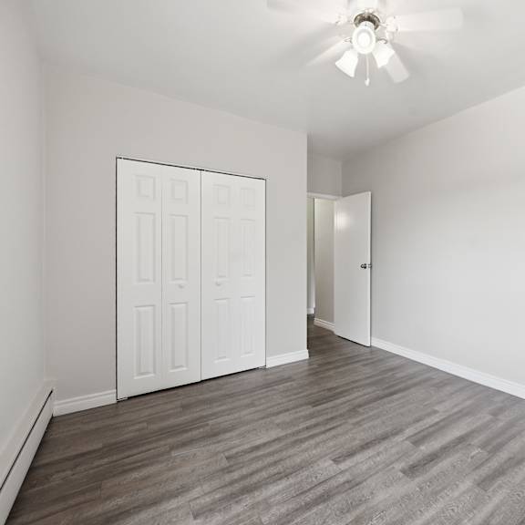 a room with a ceiling fan and a door.