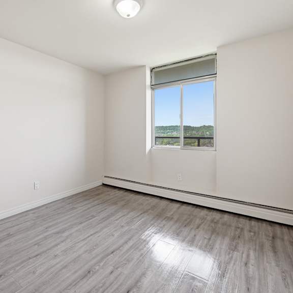 a room with a window and a wooden floor.