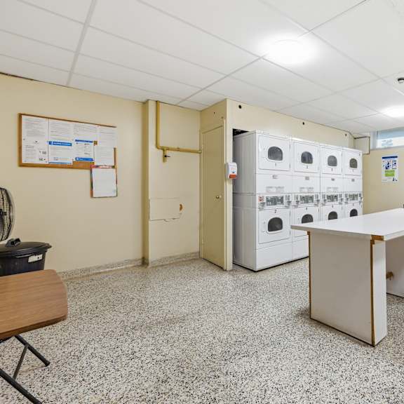 a clean, empty room with a white table and a red shopping cart.