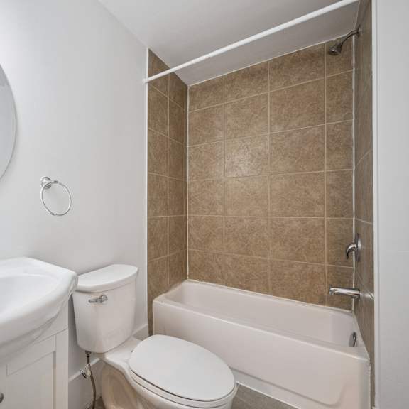 a bathroom with a toilet, sink, and bathtub.