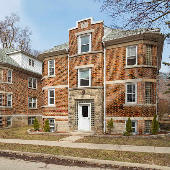 a red brick building with a white door and windows.