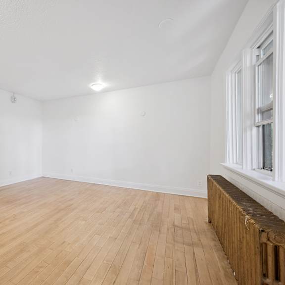 empty room with wooden floor and white walls.