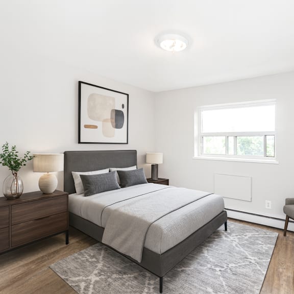 a bedroom with a bed, chair, and a painting on the wall.