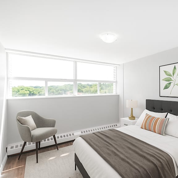 a bedroom with a large bed, a chair, and a window.