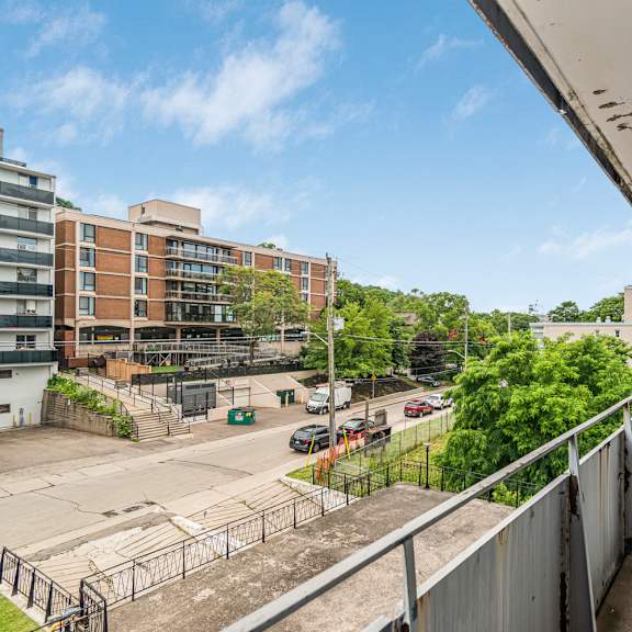 a view from a balcony looking down at a parking lot and buildings.
