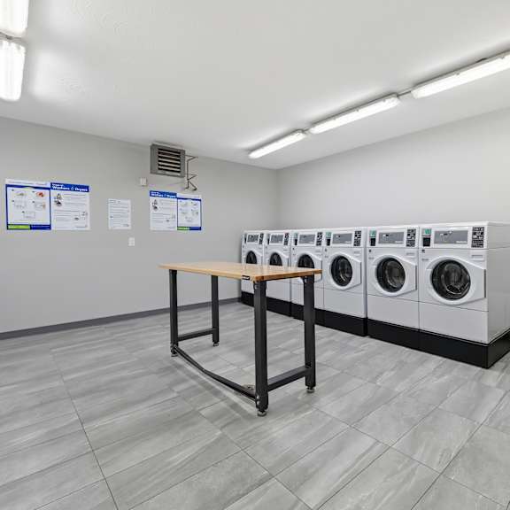 a laundry room with washing machines and a table.