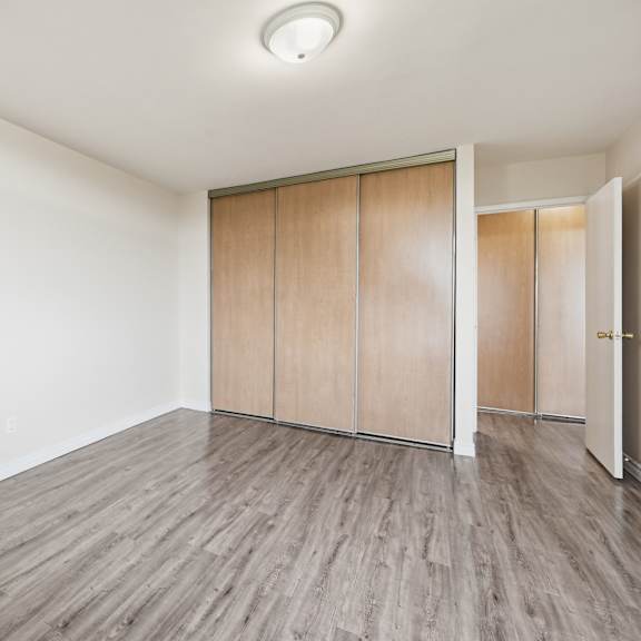 a room with wooden flooring and a wall-mounted light fixture.