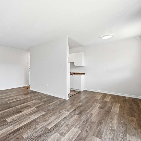 a room with wooden flooring and white walls.