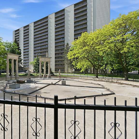 a black fence with a decorative design surrounds a circular courtyard.