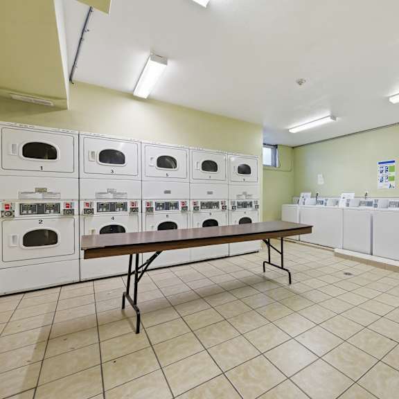 a room with a row of ovens and a table in the middle.
