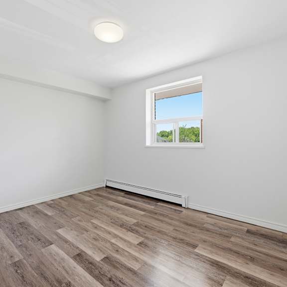 a room with a window and wooden flooring.