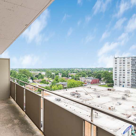a balcony with a view of a parking lot and buildings.