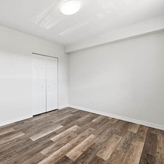 a room with wooden flooring and white walls.