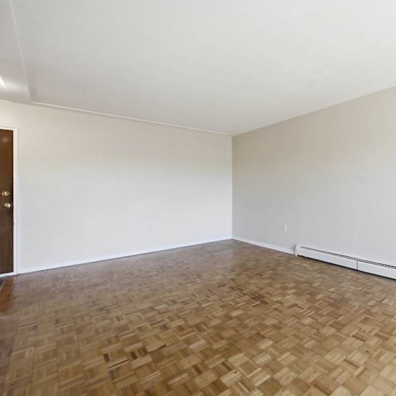 a room with a wooden floor and a white wall.