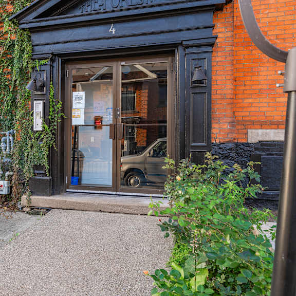 a red brick building with a black door and a sign that says "fisher onslow".