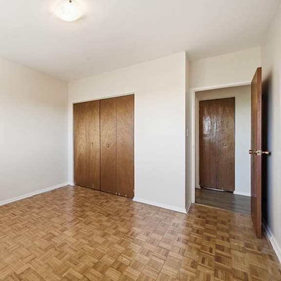 a room with wooden flooring and two brown doors.
