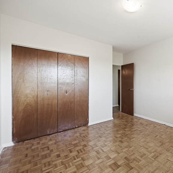 a room with a wooden floor and two brown cabinets.