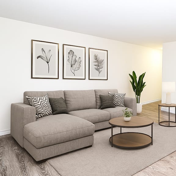 a living room with a grey sofa, a coffee table, a chair, and three framed pictures on the wall.