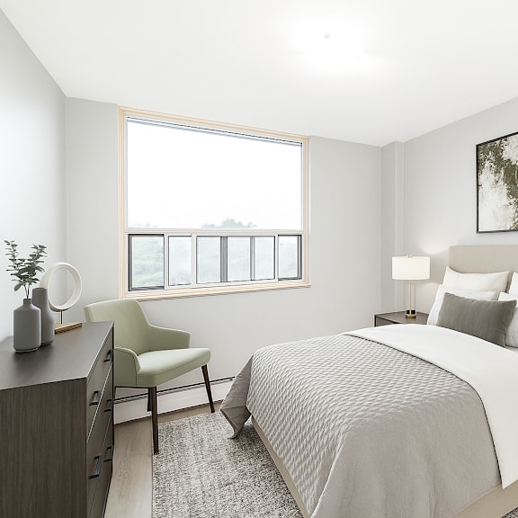 a bedroom with a large bed, a chair, and a window.