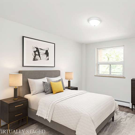 a bedroom with a bed, chair, and a picture on the wall.