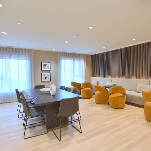 a modern dining room with a long table and chairs at roxy apartments, hamilton, on, l8h 0b7