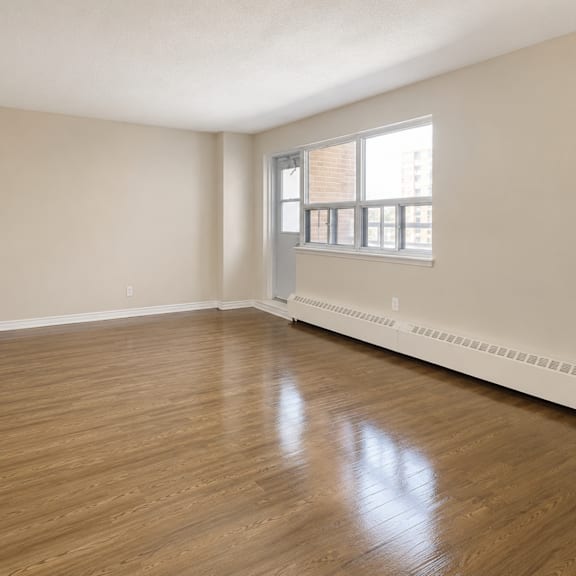 empty room with wooden floors and a window.