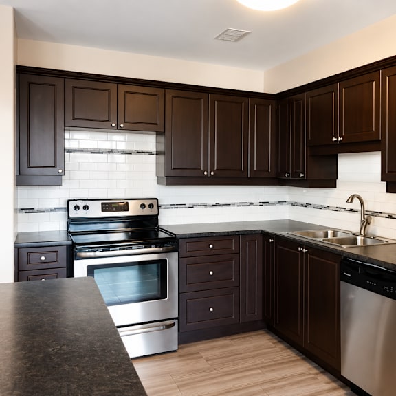 a kitchen with dark brown cabinets and stainless steel appliances.