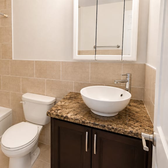 a bathroom with a white toilet, sink, and bathtub.