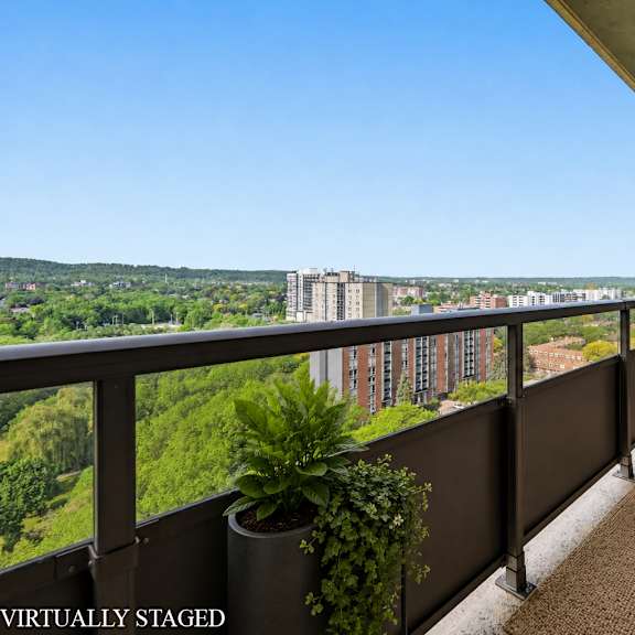 a balcony with a table and chairs overlooking a cityscape.