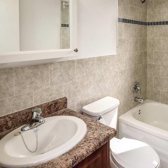 a bathroom with a sink, toilet, and bathtub.