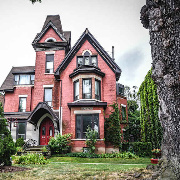 a large red house with a green tree in front.