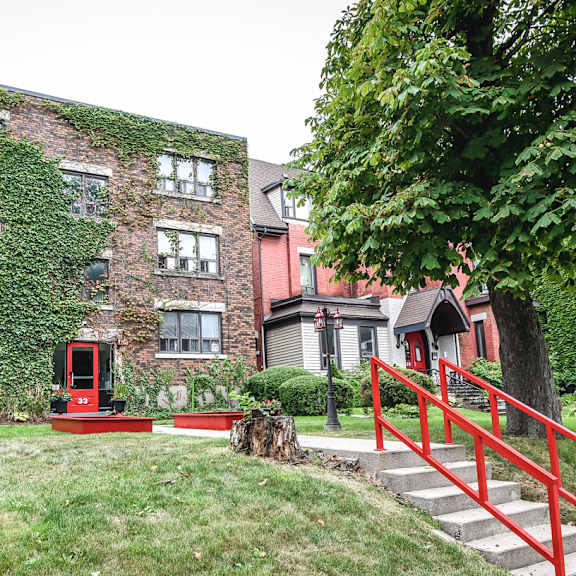 a red staircase leads up to a building with a red door.