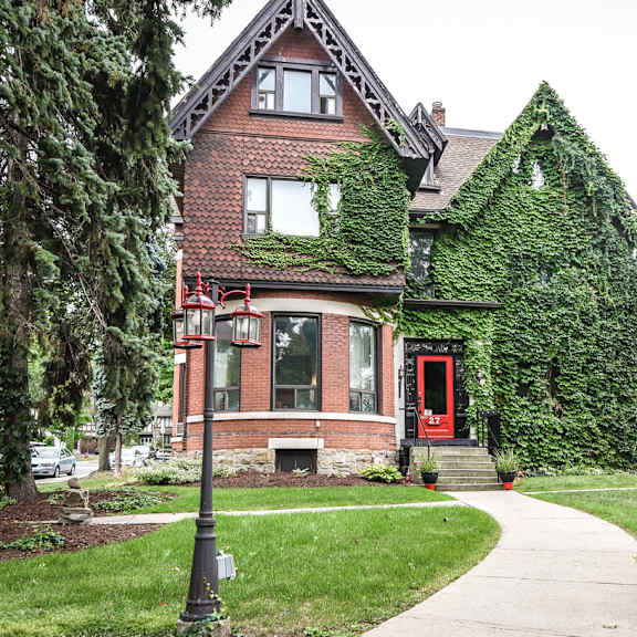 a house with a red door and a green plant on the wall.