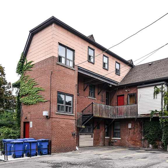 a two-story building with a red door and a balcony.